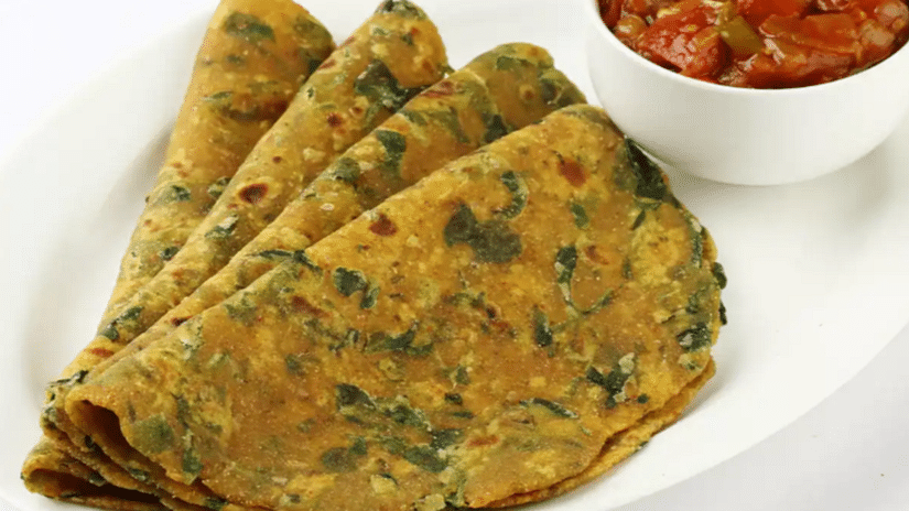 A side view of delicious thepla served on a plate, accompanied by a vibrant chutney for a burst of flavour.
