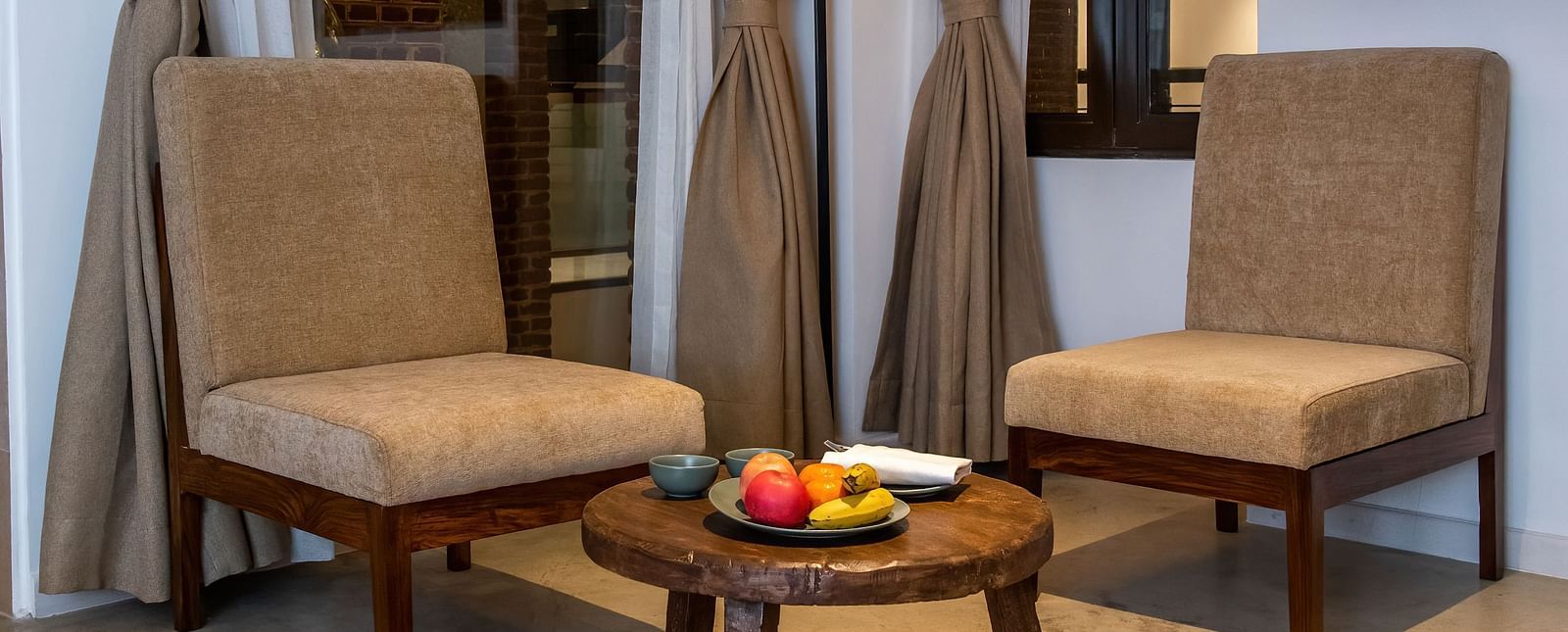 The room at The Nanee features chairs, a table, a flat-screen TV, and a rug.