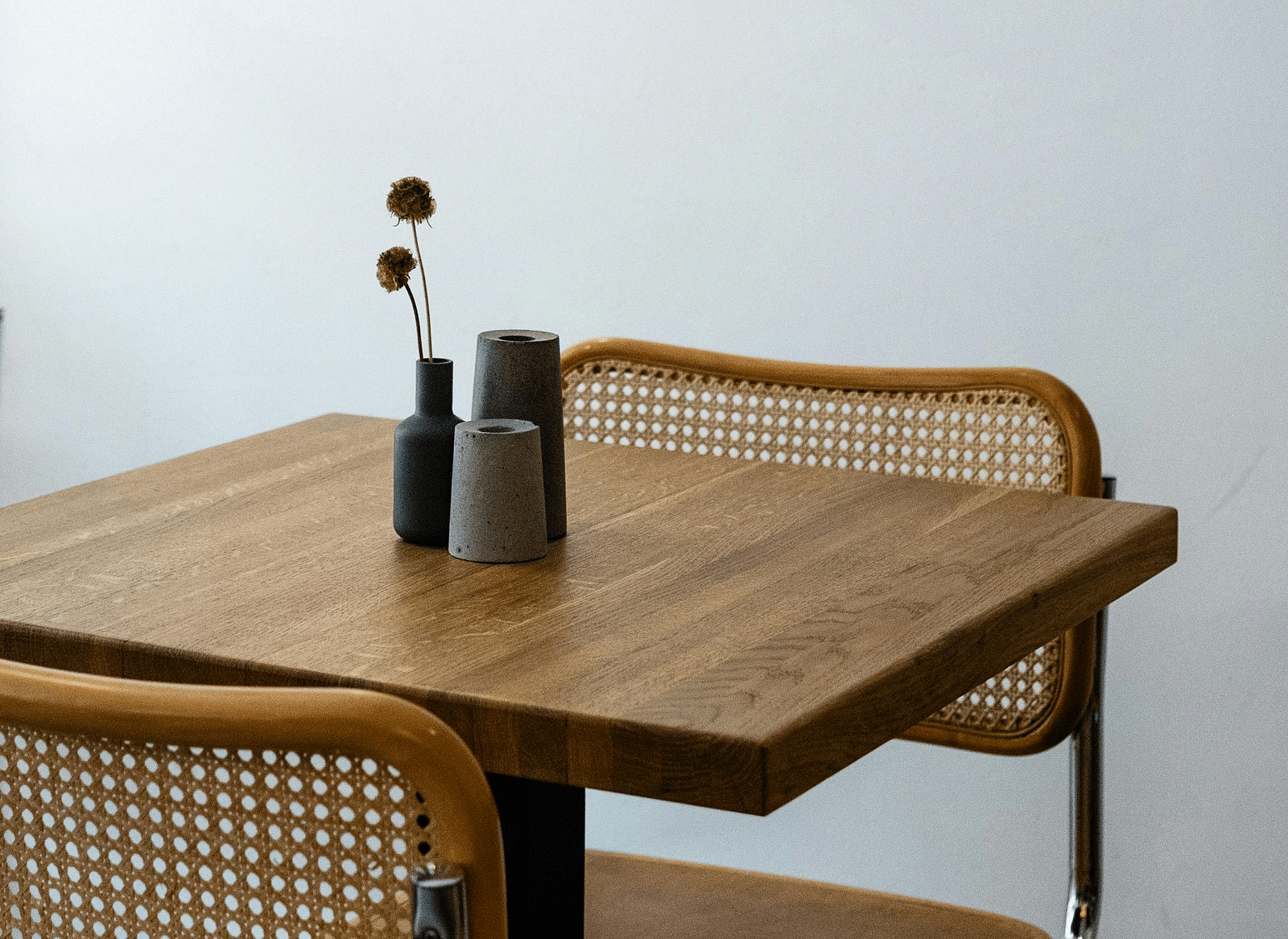 A minimalist set up of a table with a flower vase placed on the top.