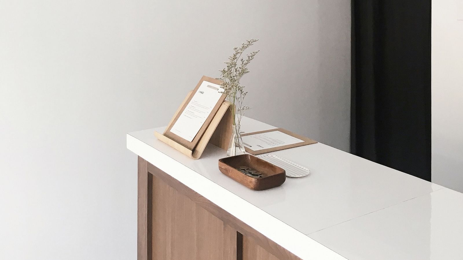 A travel desk with a notepad and a lamp hung over it