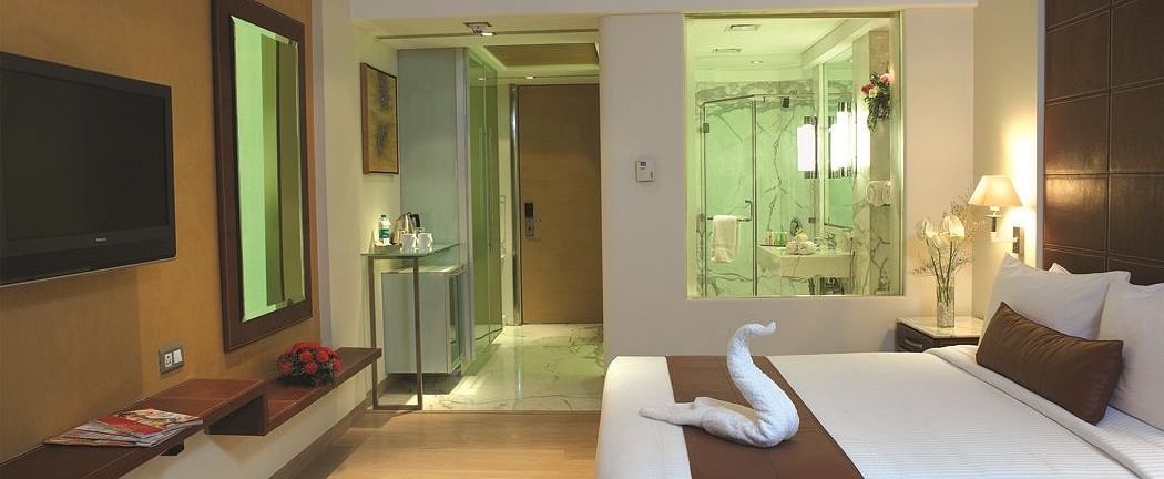 Shot of reflection room at our hotel featuring a king size bed that as a towel art, flat screen television, expansive window | Mirage Hotel