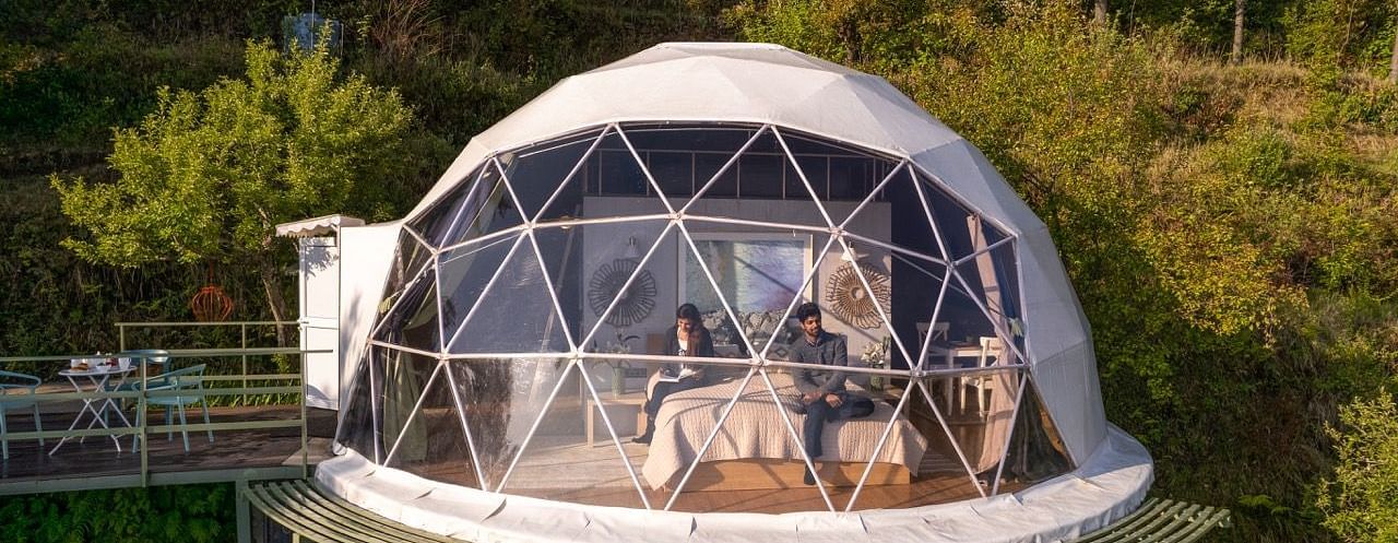 A closer view of a dome cottage with a couple inside | Avalon Cottages, Kanatal