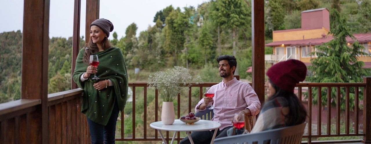 An image of a group of friends enjoying the view and wine | Avalon Cottages, Kanatal