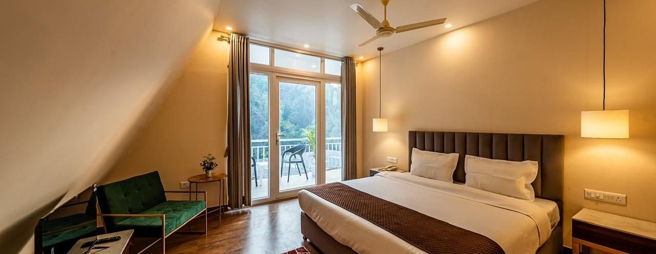 A hotel room showing a bed, a TV, and a door to the balcony.