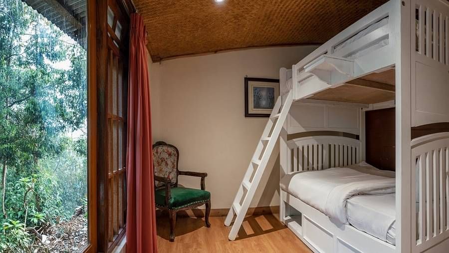 A room at Summit Barsana Resort & Spa, Kalimpong with bunk beds and large windows