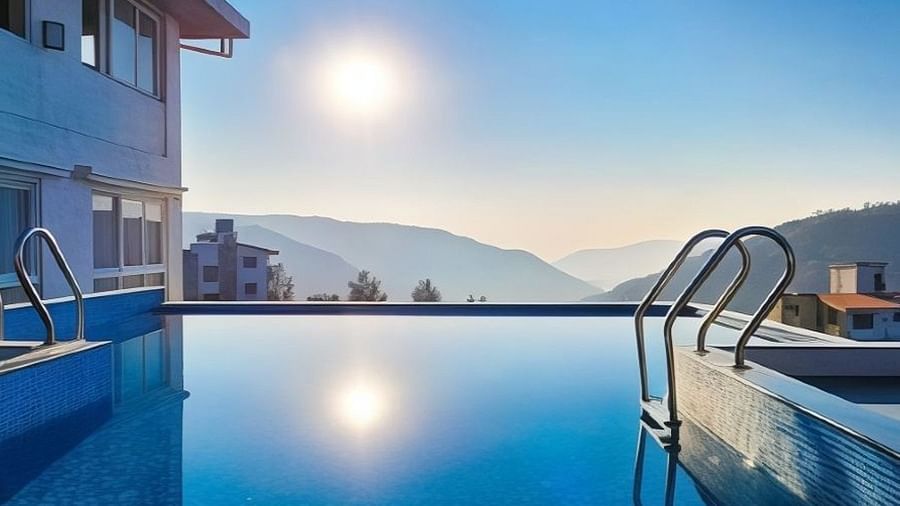 The outdoor swimming pool at VITS Panchgani during the day with the hills in the backdrop
