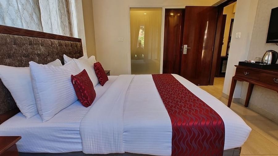 A double bed and a television in the suite at VITS Panchgani