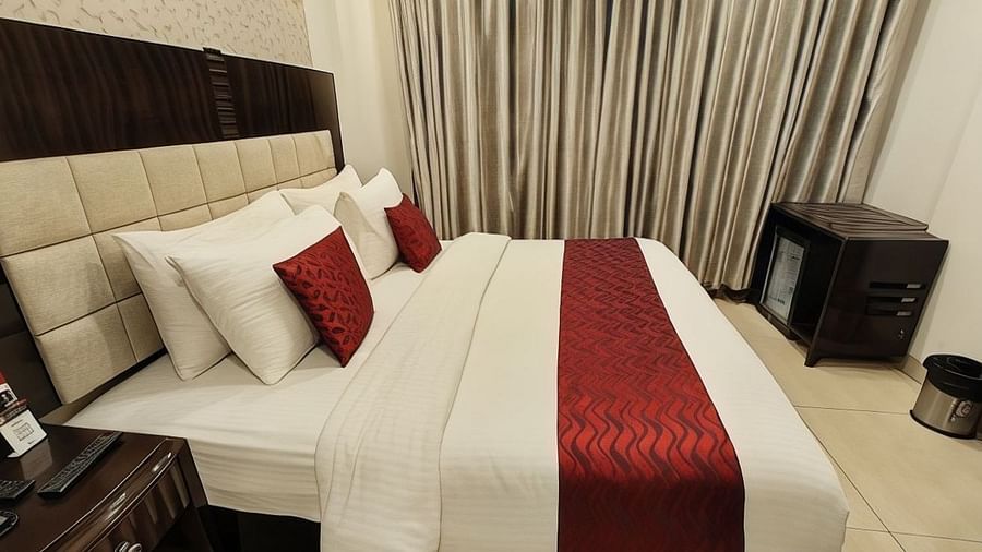 The suite at VITS Panchgani with a double bed, side tables and a minibar
