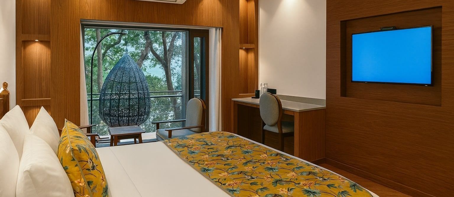 Premium Ganges View Room with Bathtub at Summit by the Ganges Beach Resort and Spa, Rishikesh showcasing a bed, a work desk and chair, an AC, a flat TV screen, and a balcony attached.