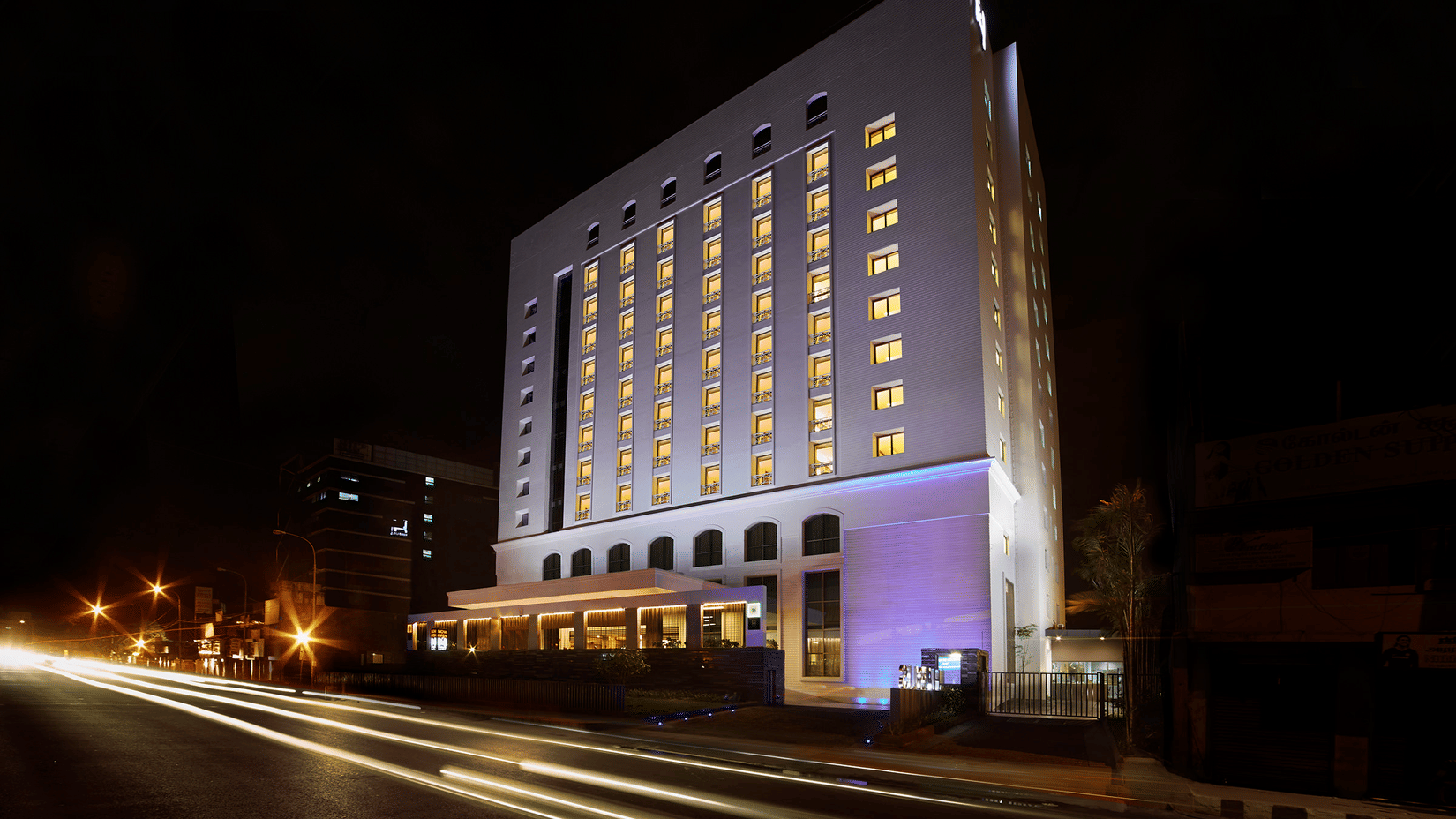 Facade of Hablis Hotel Chennai - a Hotel near Phoenix Mall, Chennai, illuminated with lights inside the building and outside at night