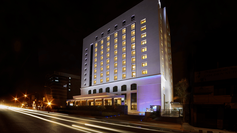 Facade of Hablis Hotel Chennai - a Hotel near Phoenix Mall, Chennai, illuminated with lights inside the building and outside at night