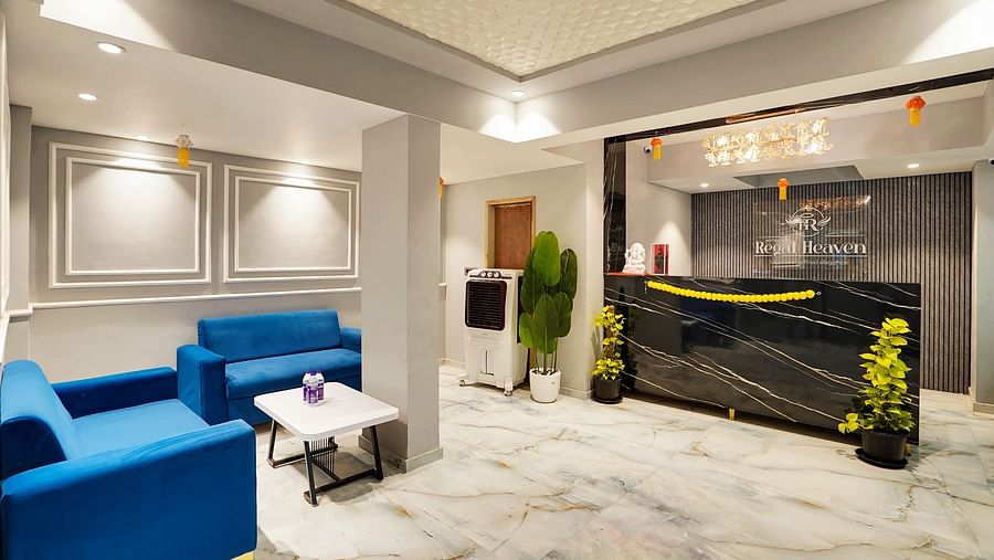 Reception area with seating area in front of the reception desk at Hotel Regal Heaven, Pune.