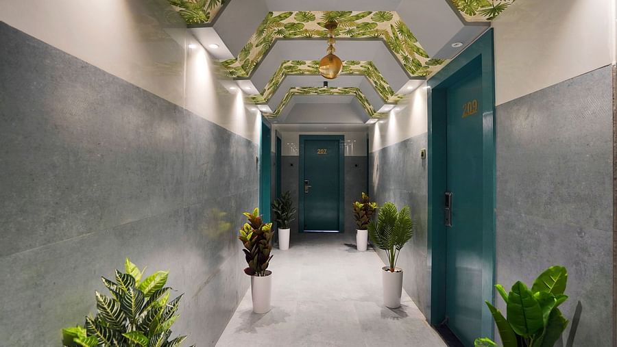 Lobby area of Hotel Regal Heaven, Pune with plants placed on either side of the hallway.