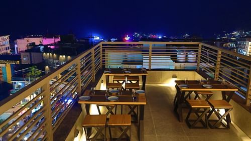 Image of Sky Deck rooftop restaurant featuring tables and chairs placed under the night sky