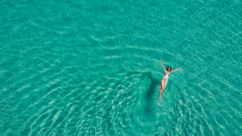 person swimming in turquoise waters