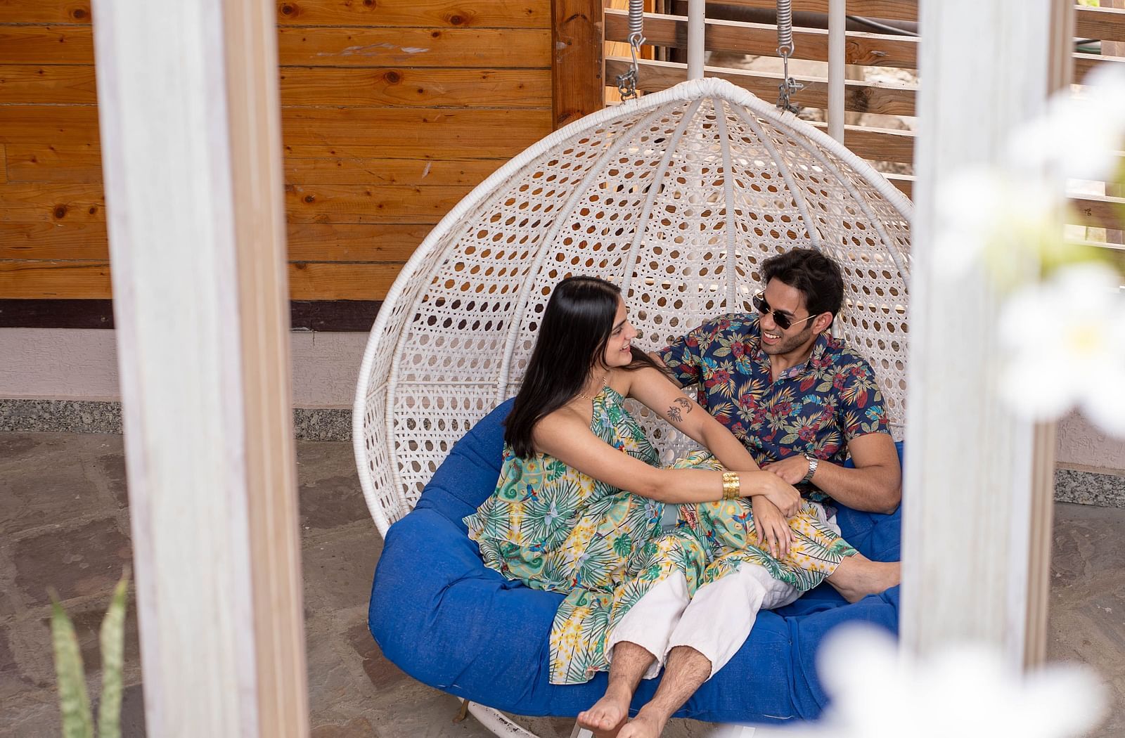 Two people sitting in a hanging chair or swing.