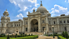 The pathway to the Victoria Memorial surrounded by lush well manicured lawns.