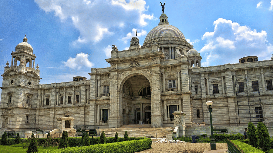 The pathway to the Victoria Memorial surrounded by lush well manicured lawns.