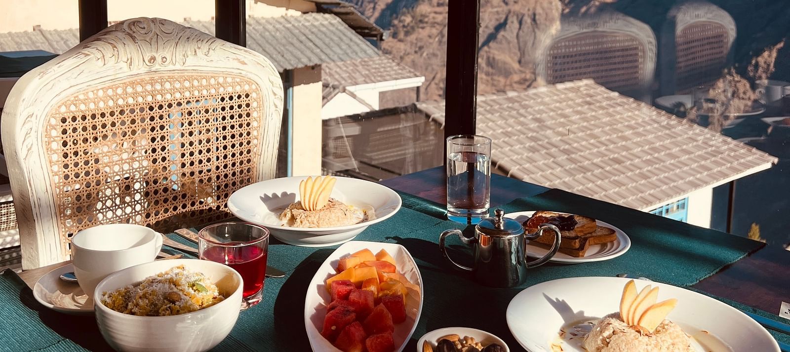 Image of a variety of food on a table and veiws of the mountian | Faraway Cottages, Auli