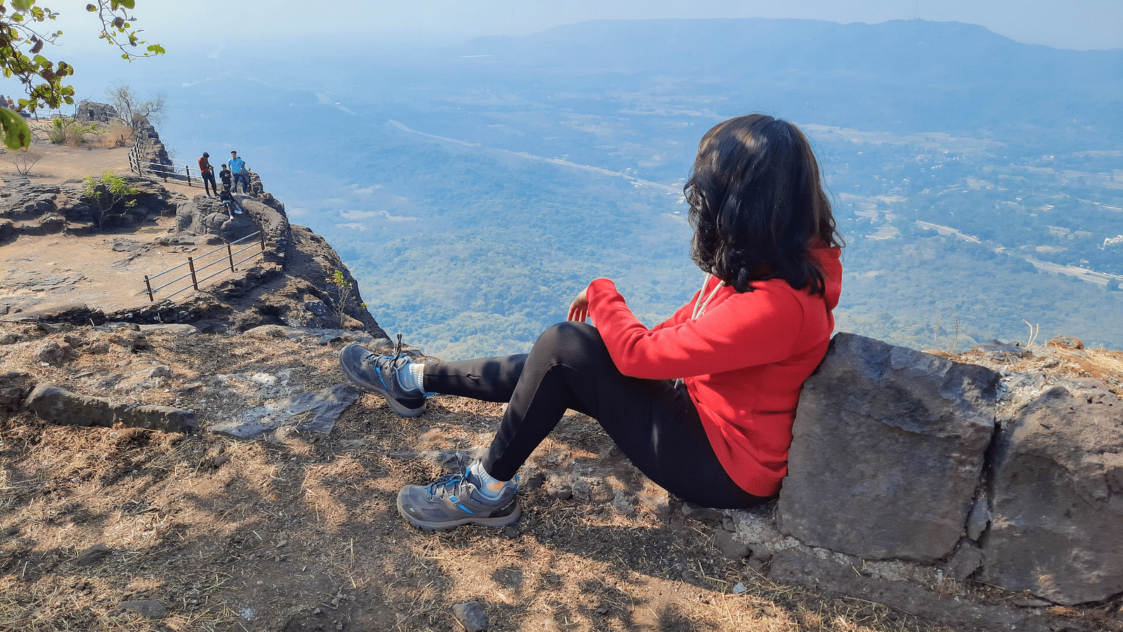 A person rests on the top of the fort overlooking the vast natural expanse below