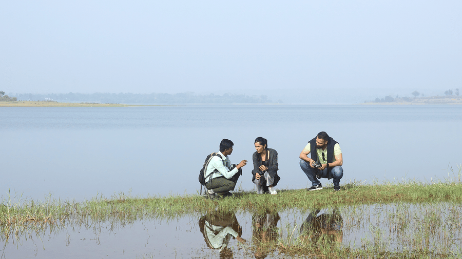 Guests sitting at the edge of the Kabini backwaters at Evolve Back resort