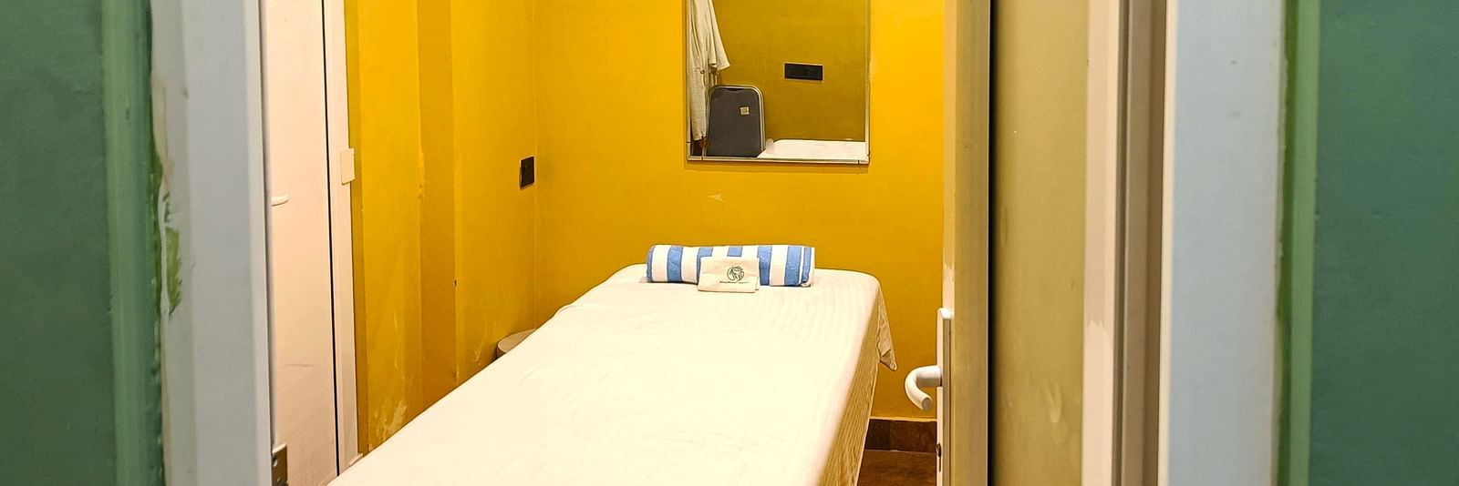 Spa room at DLS Forest Vines Resort as seen from the entrance, with a neatly made massage bed.