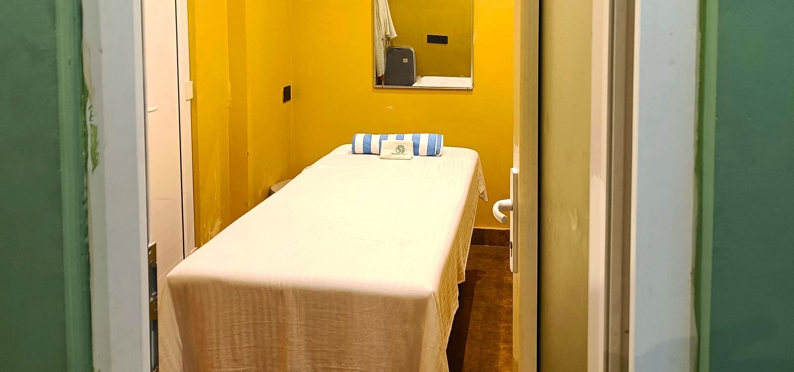 Spa room at DLS Forest Vines Resort as seen from the entrance, with a neatly made massage bed.