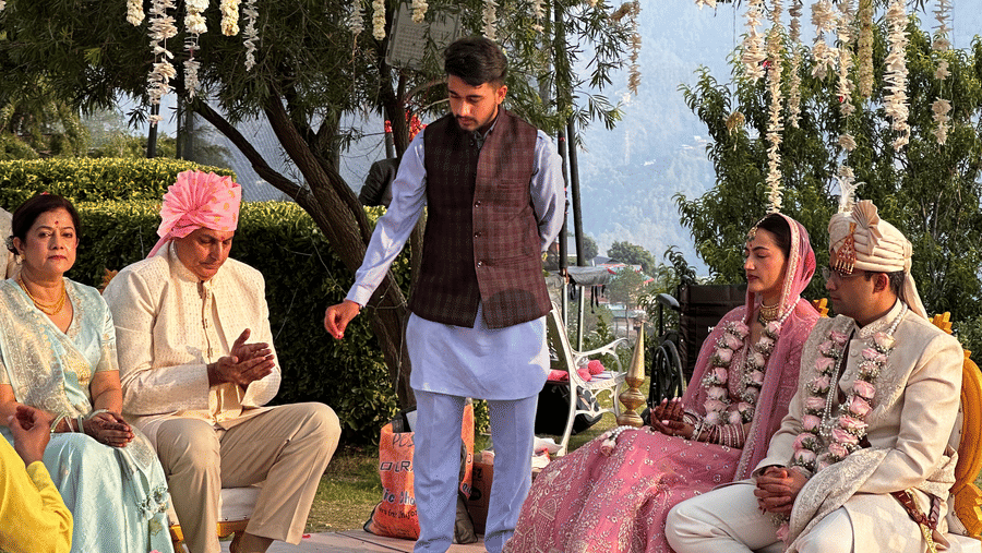 Outdoor wedding ceremony setup with guests seated among tall trees at The Manor Luxury Apartments, Shimla.