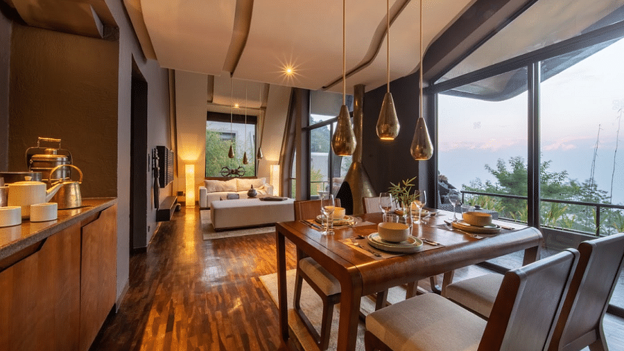 A four-seater dining table wit bespoke lighting and a large window |  Kavya Resort and Spa, Nagarkot