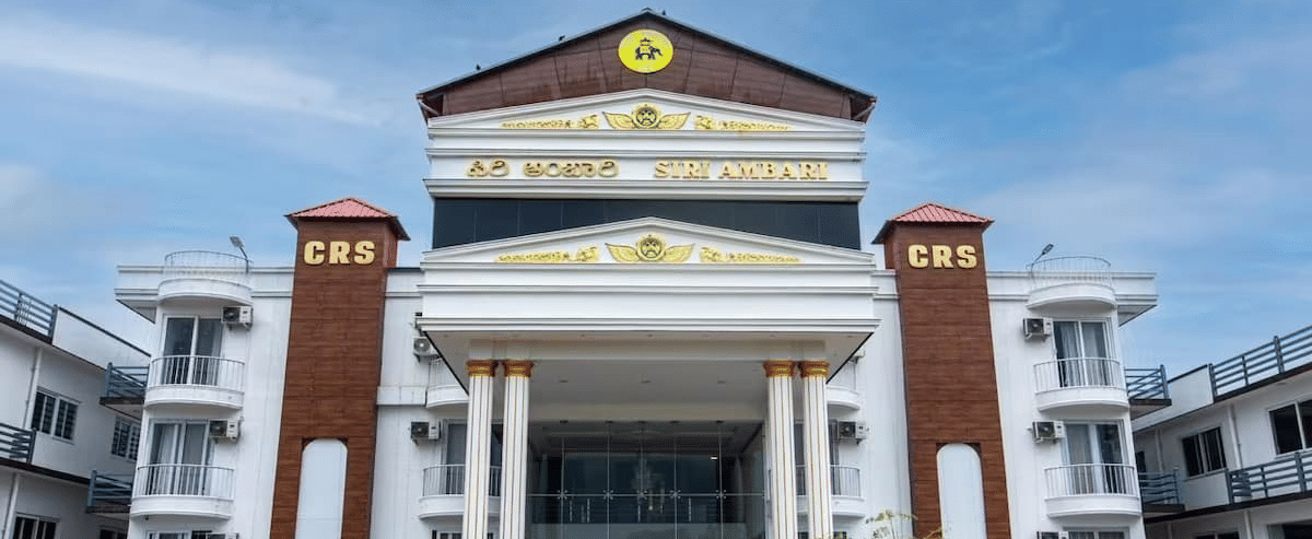 Grand exterior view of Siri Ambari Resorts and Spa, featuring a majestic white building with landscaped gardens in front.