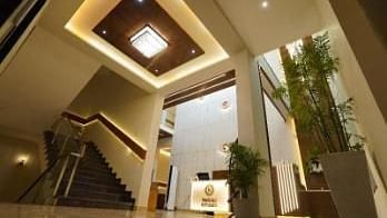 A modern lobby with a staircase and a view of the reception area.- Sukhi - A Luxury Stay Inn, Chikkamagaluru