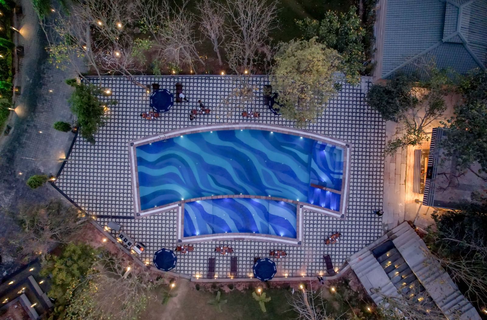 Aerial view of a swimming pool with lights around it at Essentia Luxury Resort and Spa, Udaipur