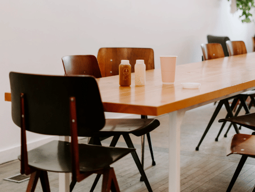 Conference room featuring a desk and few chairs around it.