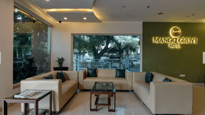 Charming outdoor seating area at Mango Grove with warm sunlight and lush surroundings.