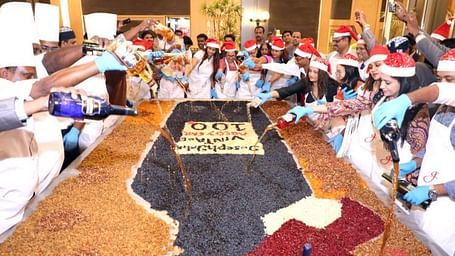 Group of people mixing ingredients for a cake together.
