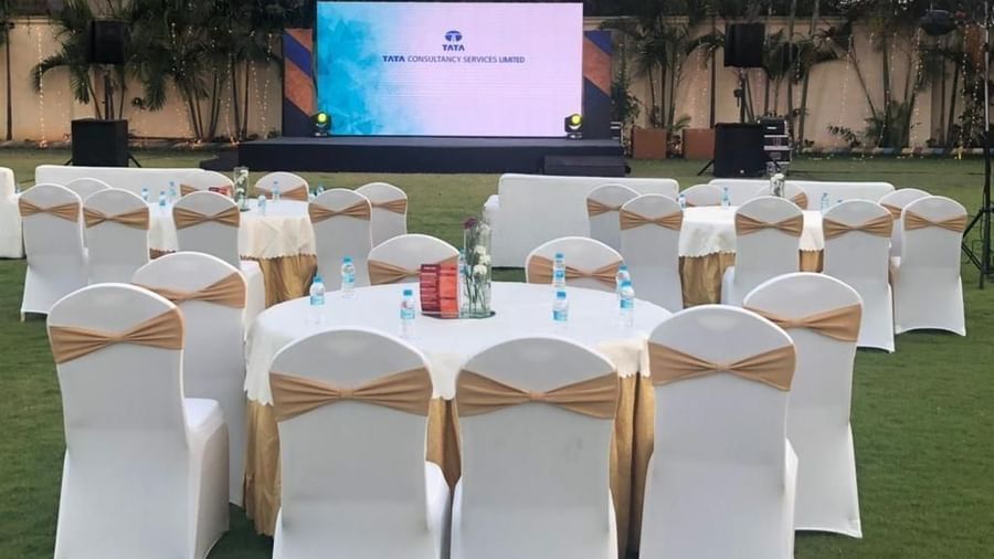 Round table banquet setup with white and gold chairs under natural lighting at Ilara Hotels & Spa, OMR, Chennai