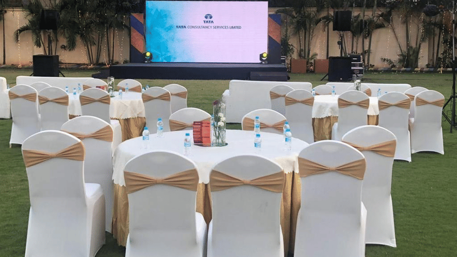 Round table banquet setup with white and gold chairs under natural lighting at Ilara Hotels & Spa, OMR, Chennai