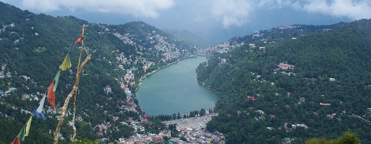 An image of a lake from a viewpoint surrounded by mountains and houses on either side 