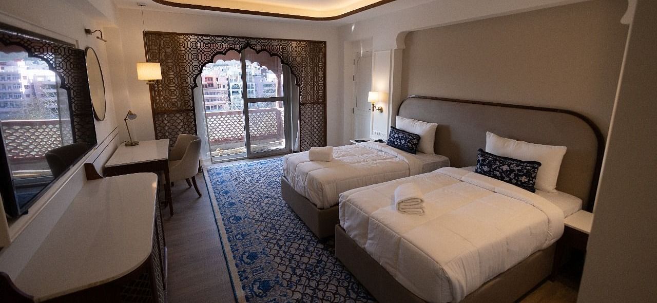 Full view shot of the Jalrupa Room with two comfortable single beds with a false ceiling at Bhagirathi by RDB Atishay.