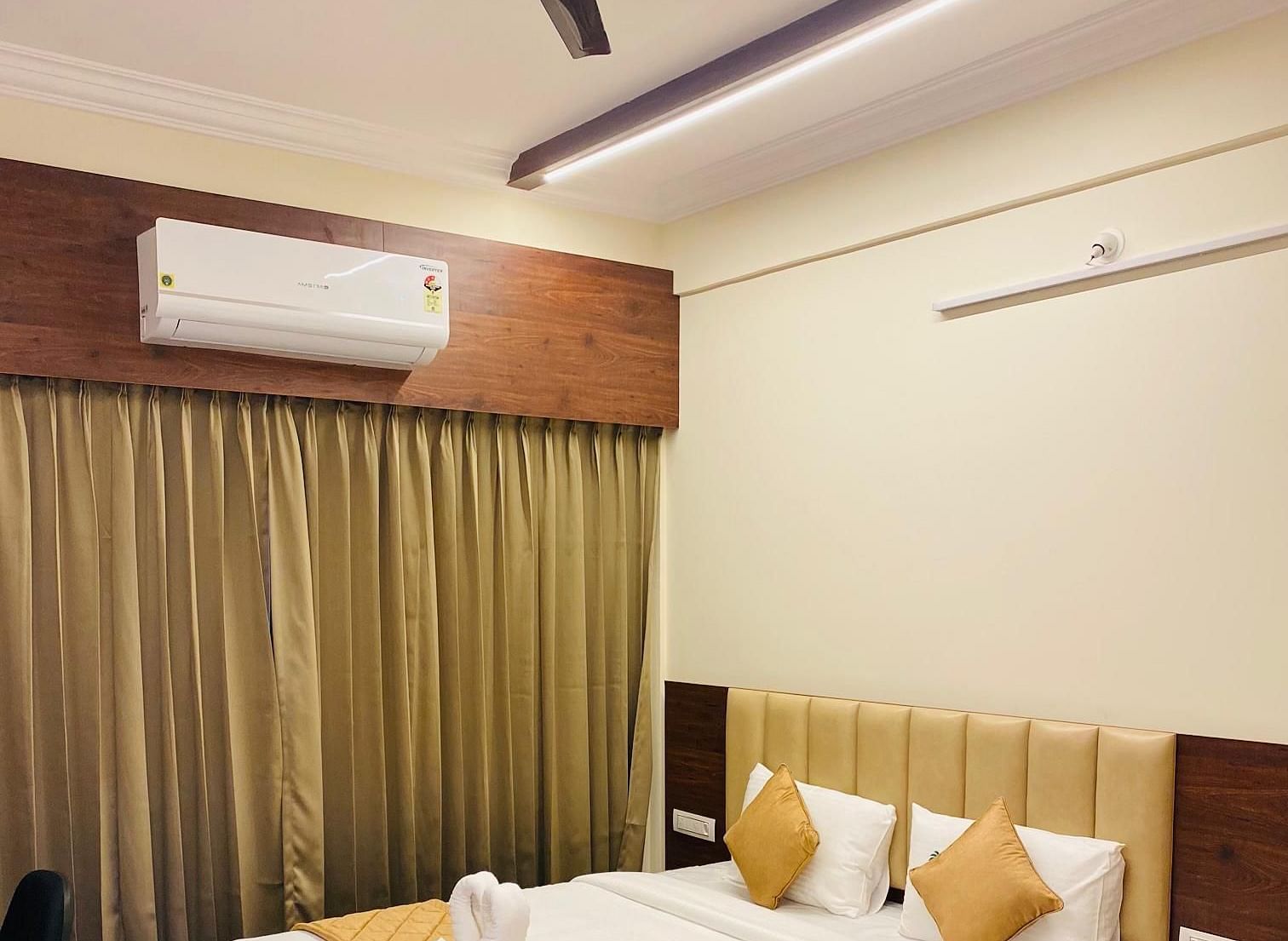 Comfortable room with golden accents, wooden furniture, and cosy lighting at Hotel Sahara Tree.