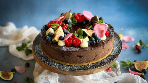A plum cake topped with berries and plums