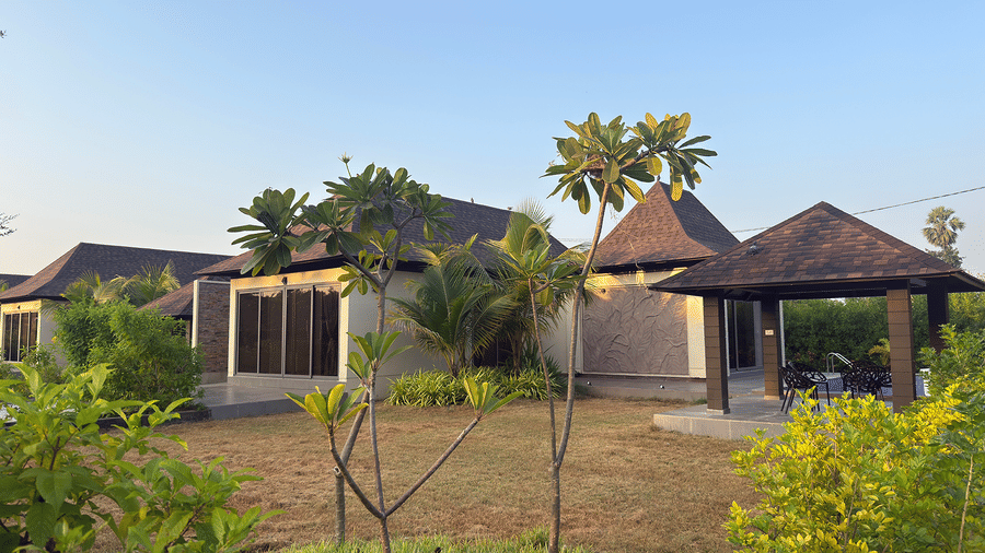 A view of modern resort cottages and a gazebo surrounded by lush tropical greenery - Daksh The Nirvana Retreat, Pavagadh