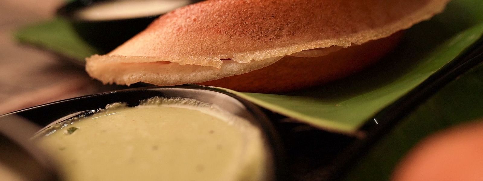 An image of dosa served with curd and pickle - Pai Group of Hotels