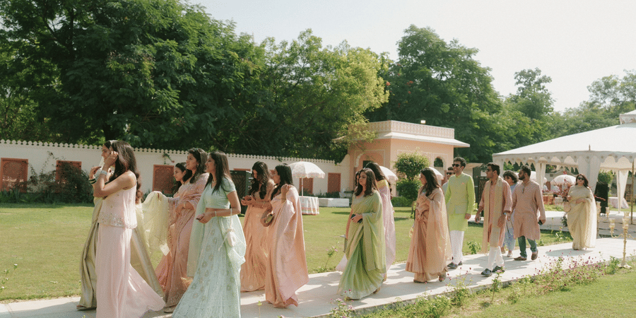 Guests walking in line along a paved stone pathway on the lawn at Umaid Palace.