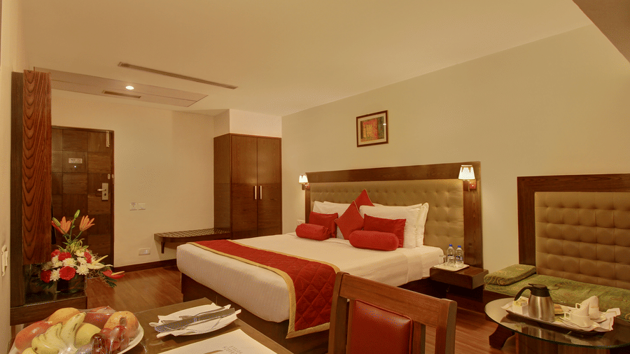 full view of executive bedroom with a king size bed and cotton linens along with contemporary amenities - The Monarch Hotel, Brigade Road