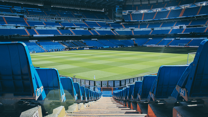 front view of a stadium with row of seats leading up to the field.
