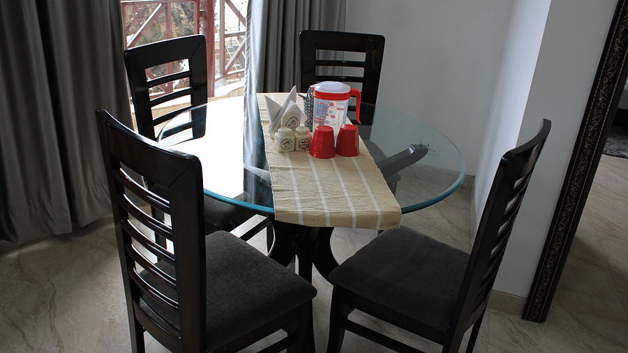 A high angle shot of a dining table surrounded by four chairs | Silverpine Apartments & Homestay, Mehli
