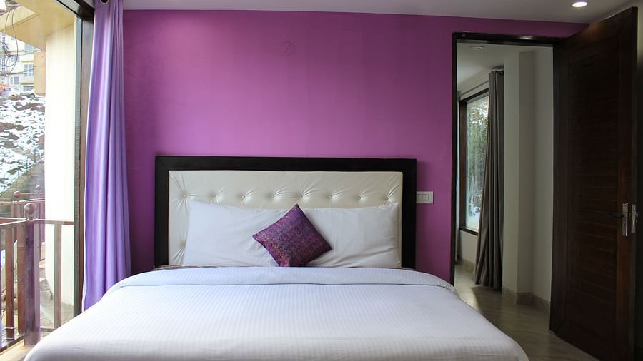 A front view of a bed with a purple with behind it - Silverpine Apartments & Homestay, Mehli