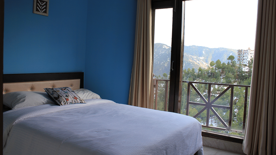 A king size bed placed beside the attached balcony - Silverpine Apartments & Homestay, Mehli