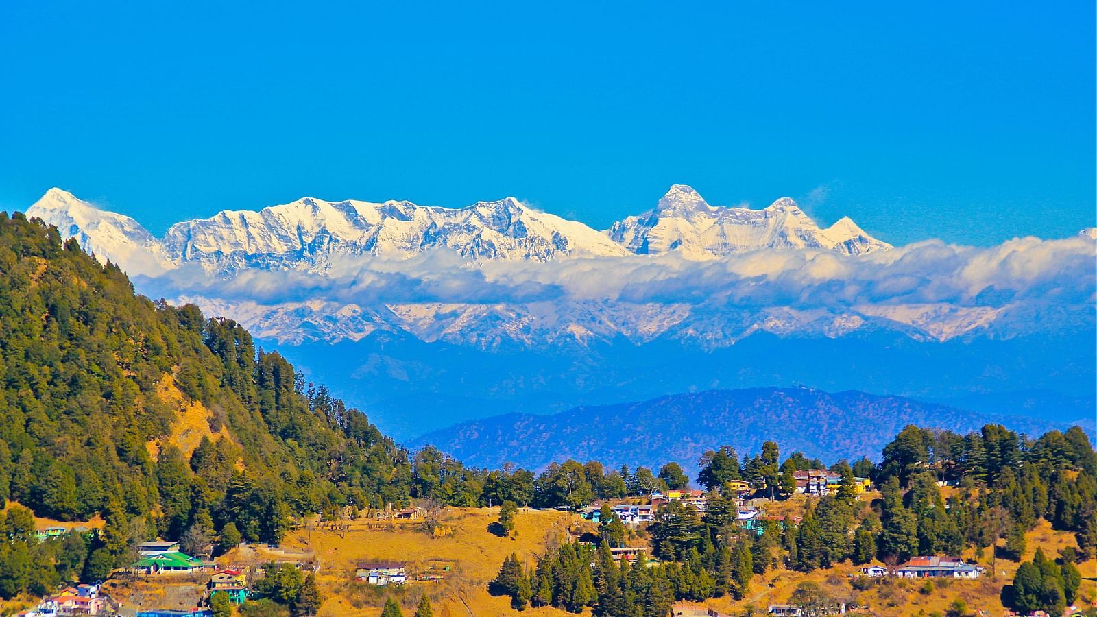 A panoramic view of a mountain landscape with clouds and colorful flags, showcasing a beautiful valley.